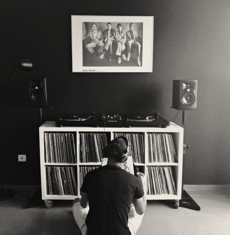 Estante de discos de vinil com gira-discos, com Fabio Rodry a escolher discos
